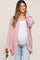 woman wearing a light pink maternity button-up shirt over a white tank top and blue jeans, showing a baby bump