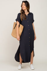 woman wearing a navy blue short sleeve button-up maternity dress with side slits, holding a straw tote bag