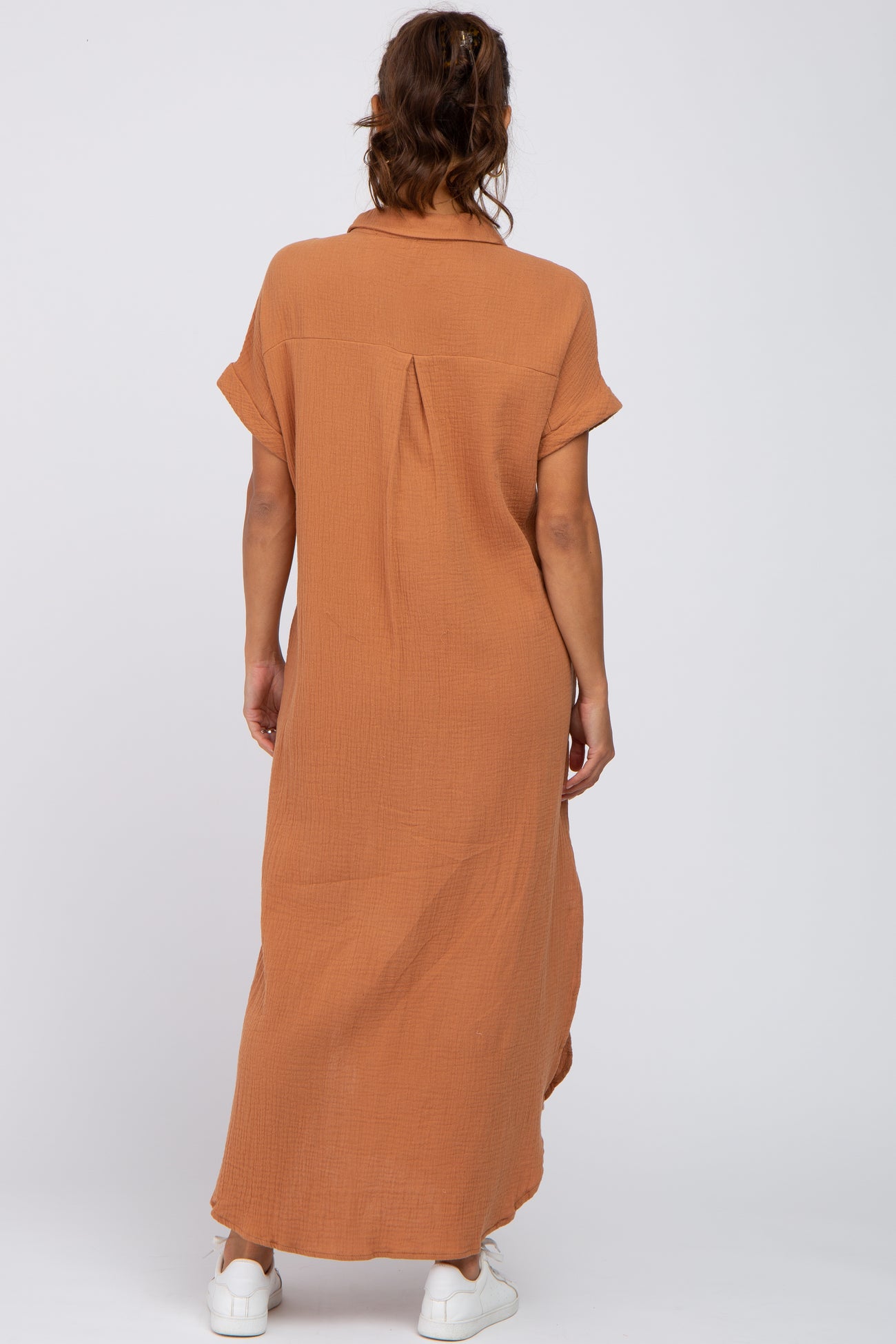 woman wearing a burnt orange maternity maxi dress with short sleeves and a back pleat detail
