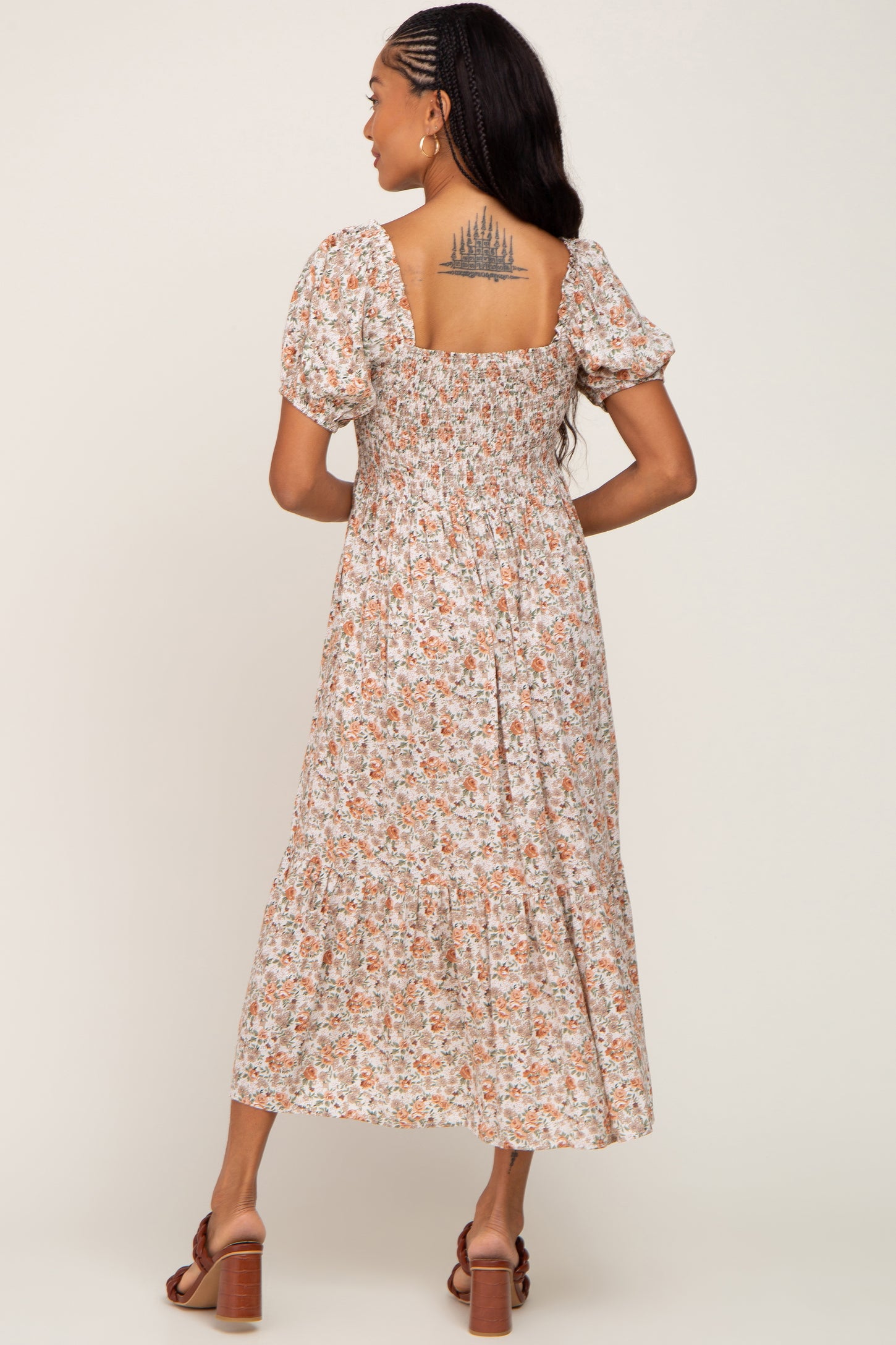 woman wearing a floral print midi dress with puff sleeves and a smocked back detail