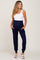 woman wearing a navy blue maternity jumpsuit with pockets and a white tank top, showcasing her baby bump