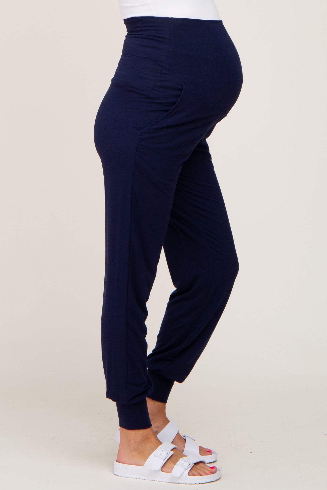 woman wearing navy blue maternity joggers with a fitted waistband and relaxed fit, showing a baby bump