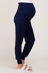 woman wearing navy blue maternity joggers with a fitted waistband and relaxed fit, showing a baby bump