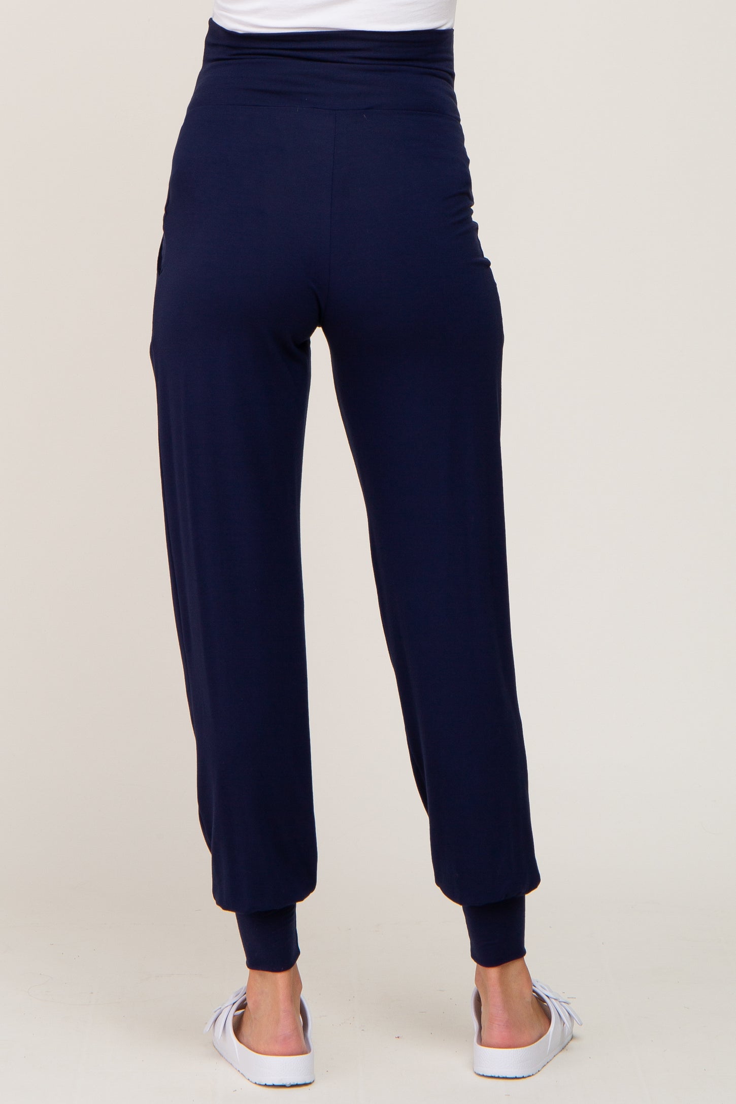 woman wearing navy blue maternity joggers with a high waistband and ankle cuffs, viewed from the back