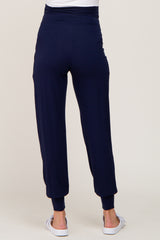woman wearing navy blue maternity joggers with a high waistband and ankle cuffs, viewed from the back