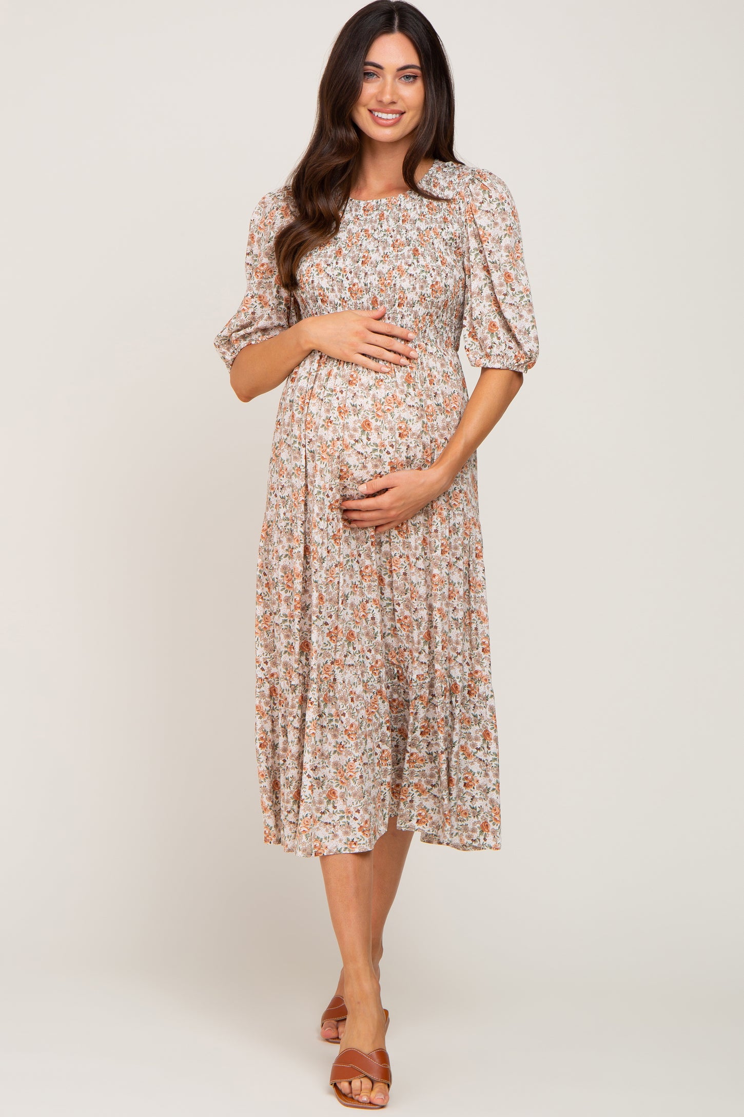 woman wearing a floral print maternity dress with puff sleeves and a baby bump