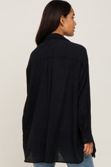 woman wearing a dark navy oversized maternity shirt with a relaxed fit and button details on the sleeves