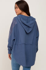 woman wearing a navy blue hooded maternity sweatshirt with a relaxed fit and back seams, shown from the back