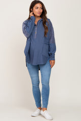 woman wearing a navy blue maternity pullover with a button-down collar and pockets, paired with skinny jeans