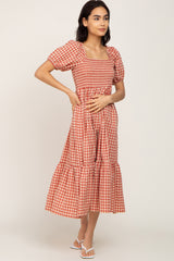 woman wearing a red and white checkered midi dress with puff sleeves and a tiered skirt, standing sideways