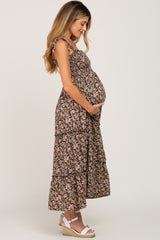 woman wearing a black floral maternity maxi dress with tiered design and holding her pregnant belly