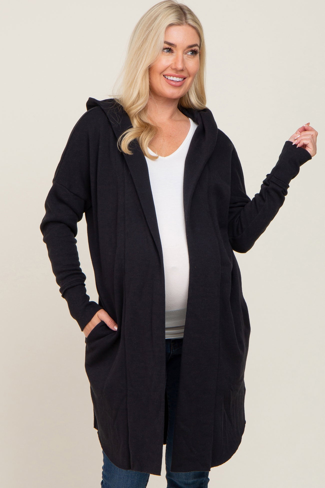 woman wearing a black maternity hoodie cardigan and showing her baby bump