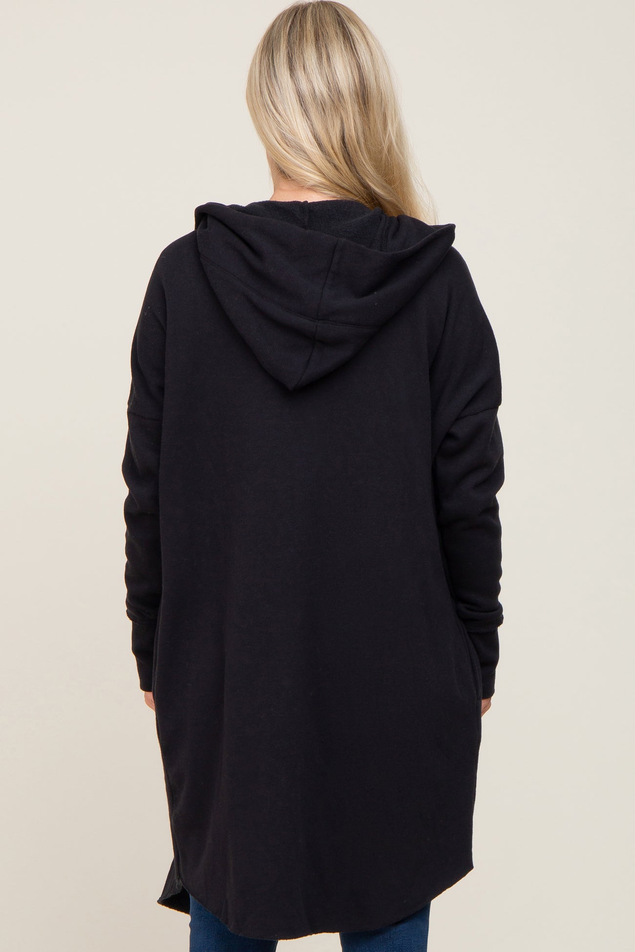 woman wearing a long black maternity hoodie with a back view showing a relaxed fit and hood