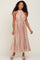 woman wearing a blush pink pleated halter neck dress with a belted waist and curly hair