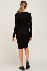 woman wearing a black long sleeve maternity dress, showing a fitted silhouette from the back