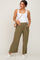 woman wearing olive green wide-leg maternity pants with pockets and a white fitted tank top, holding her baby bump