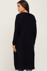 woman wearing a long black maternity cardigan with a relaxed fit, seen from the back