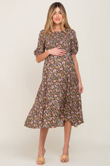 woman wearing a black floral maternity dress with short puff sleeves and a visible baby bump