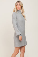 Woman wearing a grey ribbed turtleneck sweater dress with long balloon sleeves
