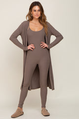 Woman wearing a mocha brown ribbed jumpsuit and matching long cardigan with tan clogs