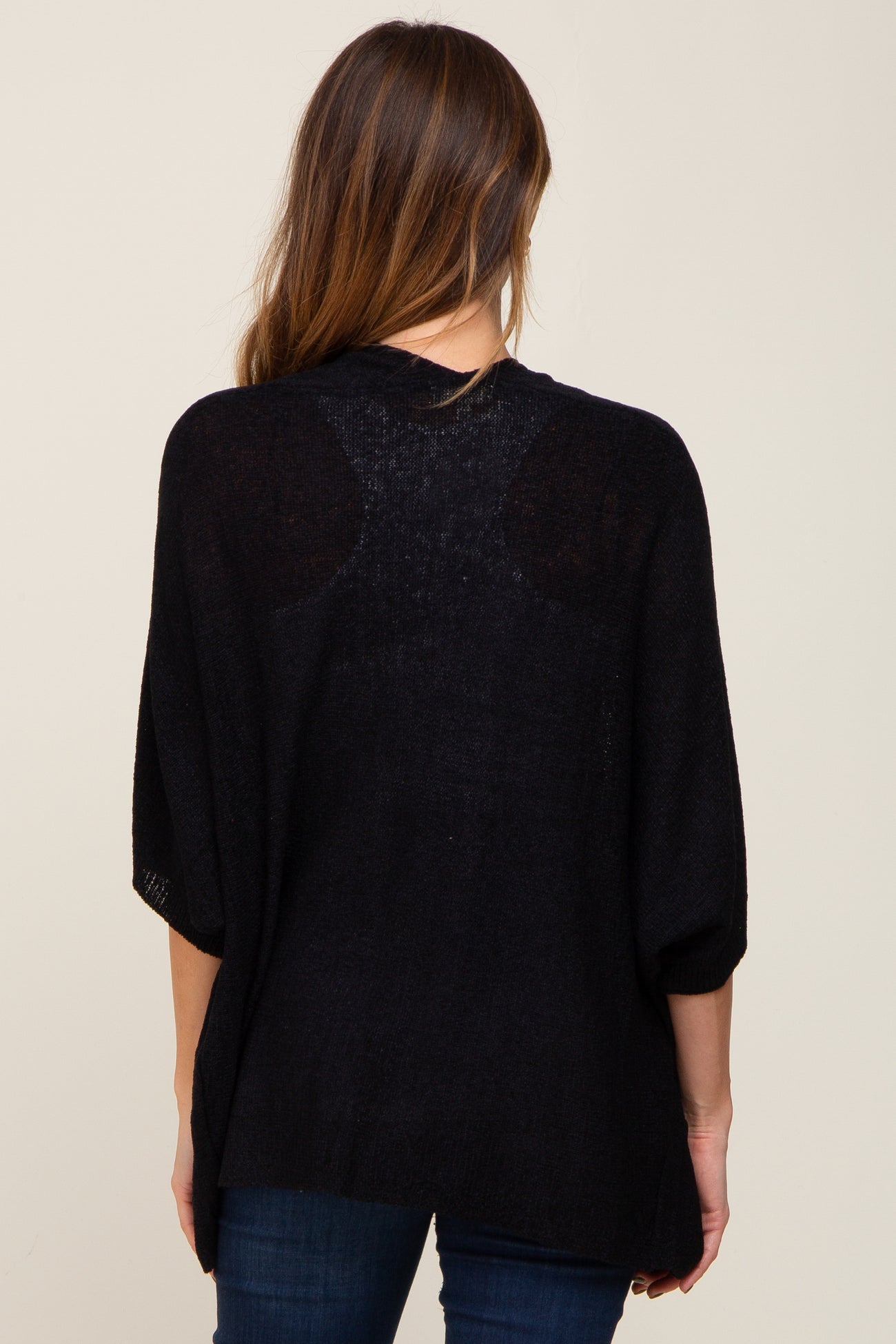 woman wearing a black oversized knit sweater with drop shoulders and a relaxed fit