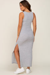 woman wearing a striped gray maternity maxi dress with side slits and showing a baby bump