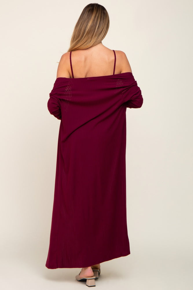 woman wearing a burgundy maternity maxi dress with a backless design and thin straps