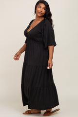 woman wearing a black tiered maxi dress with a v-neck and flutter sleeves