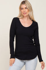 woman wearing a black long sleeve ribbed top with a scoop neckline and relaxed fit