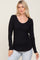woman wearing a black long sleeve ribbed top with a scoop neckline and relaxed fit
