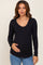 woman wearing a black ribbed long sleeve maternity top and gently cradling her baby bump
