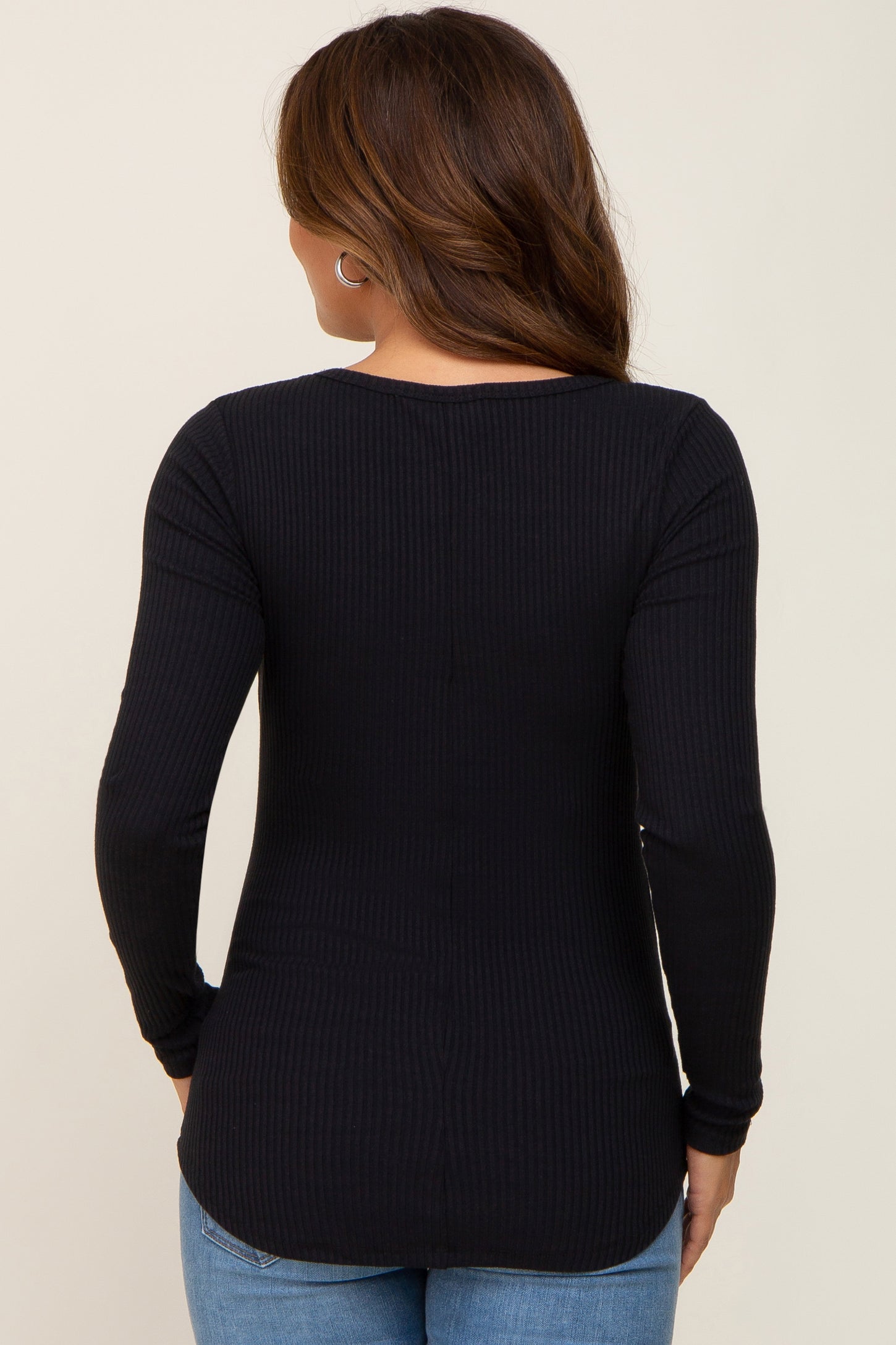 woman wearing a black long sleeve ribbed maternity top, showing the back view
