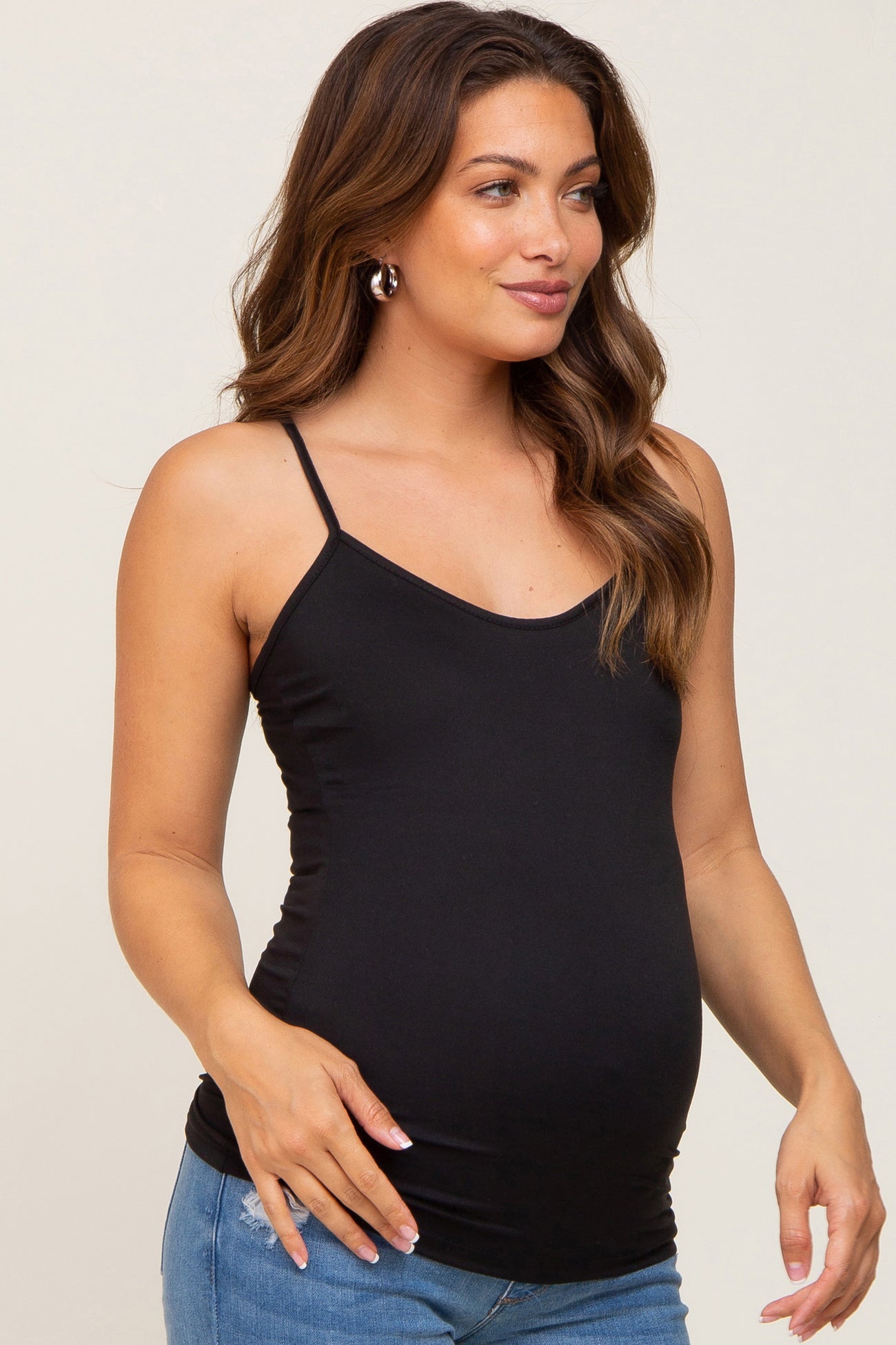 woman wearing a black maternity camisole top and showing her baby bump