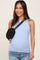 woman wearing a light blue ribbed maternity tank top and holding a black crossbody bag with a chevron design