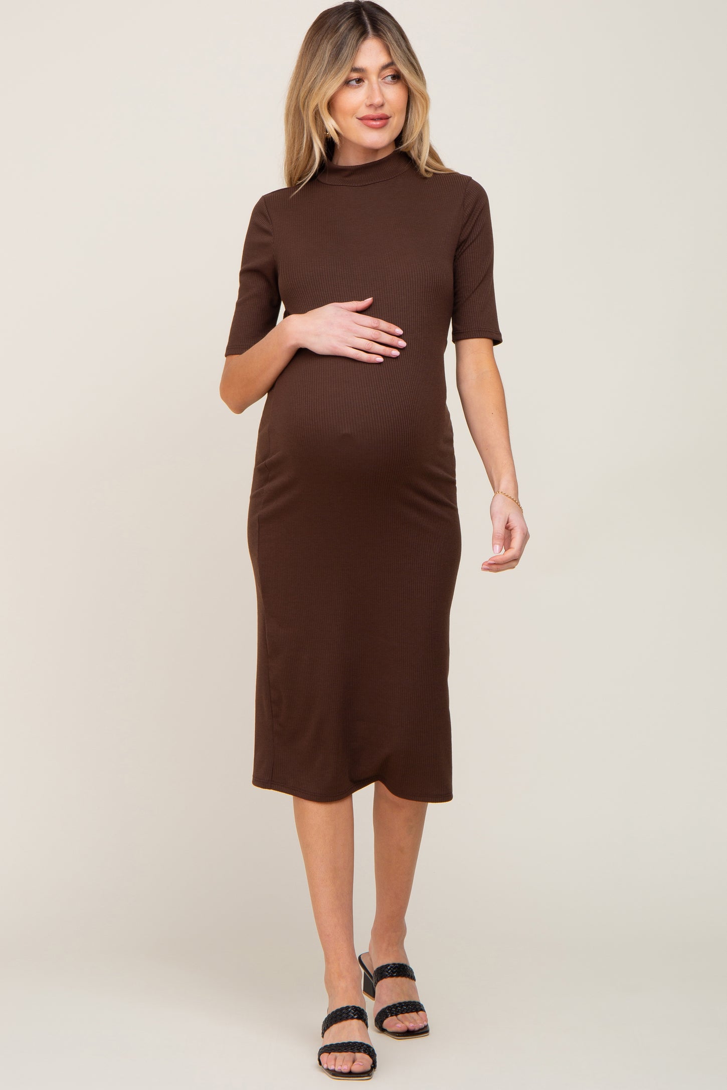 woman wearing a brown ribbed maternity dress with short sleeves and a visible baby bump