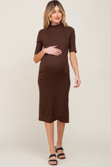 woman wearing a brown ribbed maternity dress with short sleeves and a visible baby bump