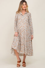 woman wearing a floral print maternity dress with a collared neckline and long sleeves, revealing a baby bump