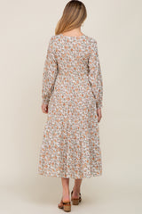 woman wearing a floral long sleeve maternity dress with a tiered skirt, showing the back view