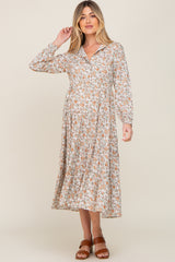 woman wearing a floral maternity dress with long sleeves and a v-neck, showing off her baby bump