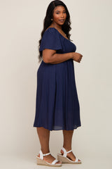 woman wearing a navy blue plus size dress with short flutter sleeves and wedge sandals