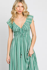 woman wearing a green striped maxi dress with ruffle sleeves and a drawstring waist