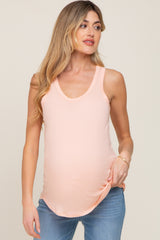 woman wearing a peach maternity tank top with a scoop neckline and a visible baby bump