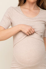 woman wearing a beige short sleeve maternity top and revealing her baby bump