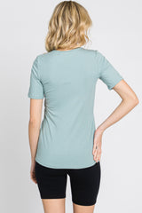 back view of a woman wearing a light sage green ribbed short sleeve t-shirt and black biker shorts