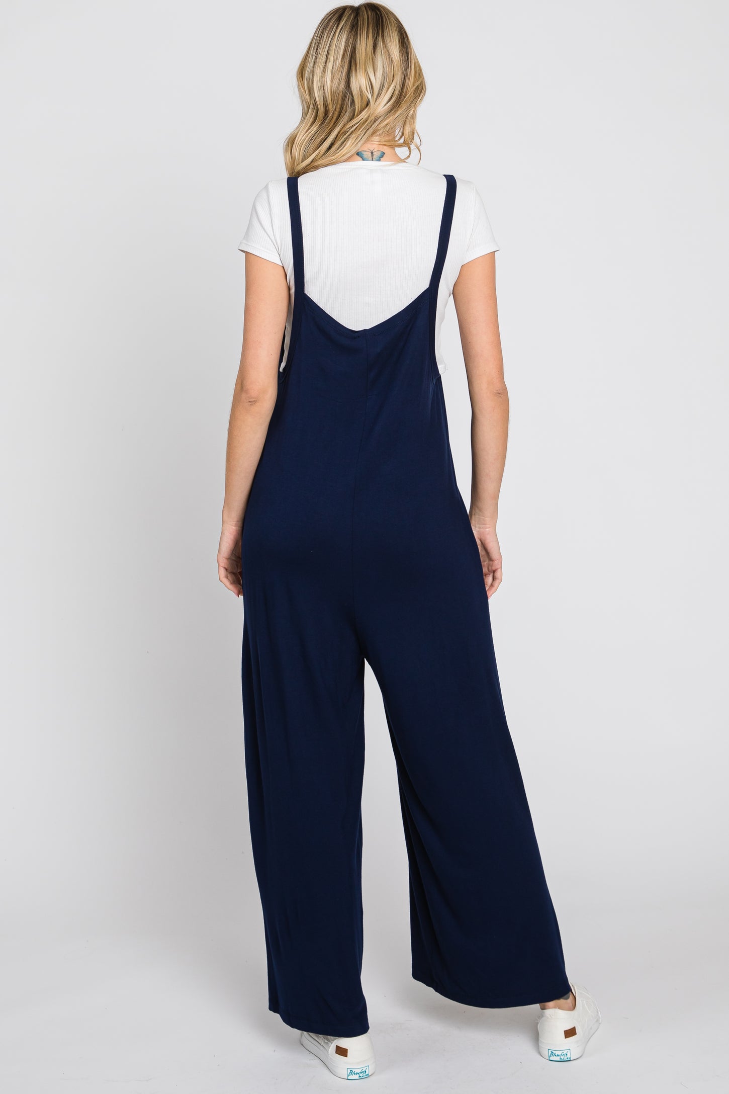 woman wearing a navy blue jumpsuit with wide legs and a relaxed fit, seen from the back