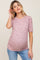 woman wearing a pink floral ribbed maternity top with short sleeves and a visible baby bump