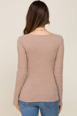 woman wearing a light brown long sleeve maternity top seen from the back
