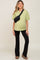 woman wearing a light green oversized maternity t-shirt and black flared pants, and posing with a crossbody bag and visible baby bump