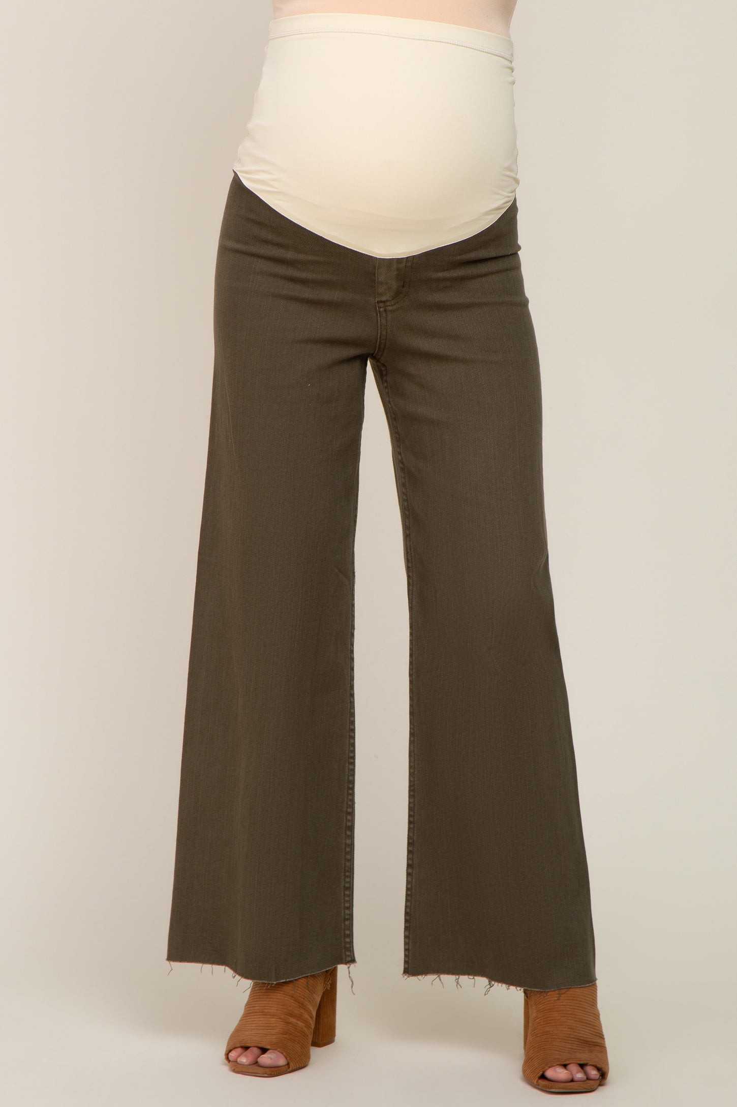 woman wearing olive green maternity wide-leg jeans with a folded waistband and a visible baby bump