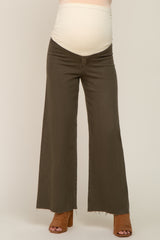 woman wearing olive green maternity wide-leg jeans with a folded waistband and a visible baby bump